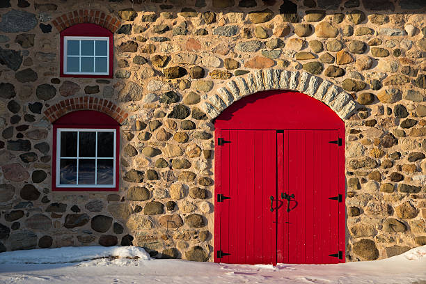 オールドストーンバーン、明るいレッドドア - barn red old door ストックフォトと画像