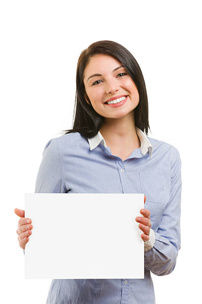 istock Smiling young woman with blank signboard 487882615