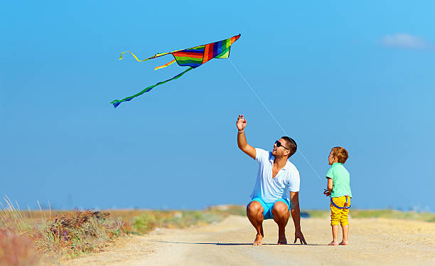 istock father and son having fun, playing with kite together 487898431