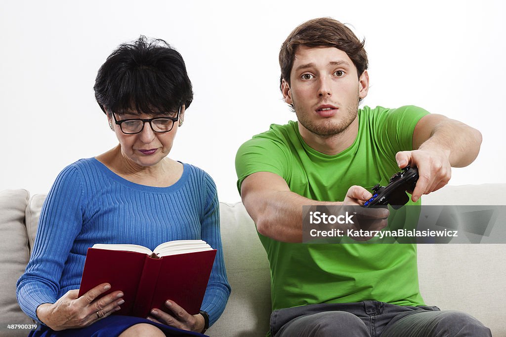 Grandmother and grandson sitting on couch Grandmother reading book and grandson sitting on couch Active Seniors Stock Photo