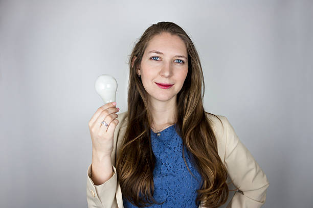 istock Woman holding unlit light bulb 487903029