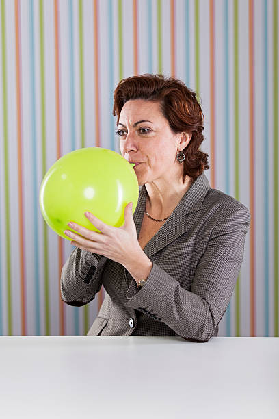 風船投げたビジネスウーマン - inflating balloon women growth ストックフォトと画像