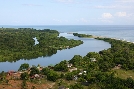 Small Village seen from the air near the Mouth of the Cuero River near La Ceiba Honduras Central America.  It is the headquarters of the Cuero y Salado Wildlife Reserve.   This is classic lowland tropical mangrove and rainforest area leading into the Caribbean Sea.