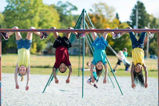 Recess Kids playing outside on a jungle gym during recess. schoolyard stock pictures, royalty-free photos & images