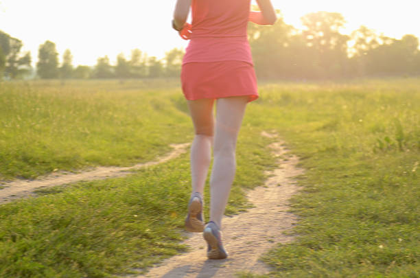 istock Blurred background: woman runner running on rural road on sunset 487910562