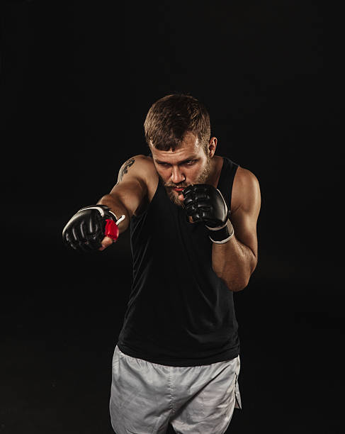 istock Athletic bearded boxer with gloves on a dark background 487913976