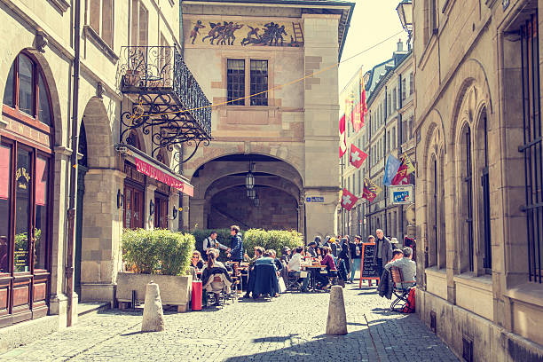 Geneva, Switzerland - November 25, 2025: This stock photo captures the vibrant street life on Rue de la Croix d’Or, one of Geneva’s most elegant and bustling shopping streets. Known for its luxury boutiques, charming cafés, and historical buildings, the street showcases a blend of modern urban energy and classic Swiss architectural character.Local residents and visitors can be seen walking, shopping, and enjoying the lively city atmosphere. The scene reflects Geneva’s unique blend of cosmopolitan sophistication and relaxed European charm, making it ideal for themes of lifestyle, travel, culture, and modern city living.