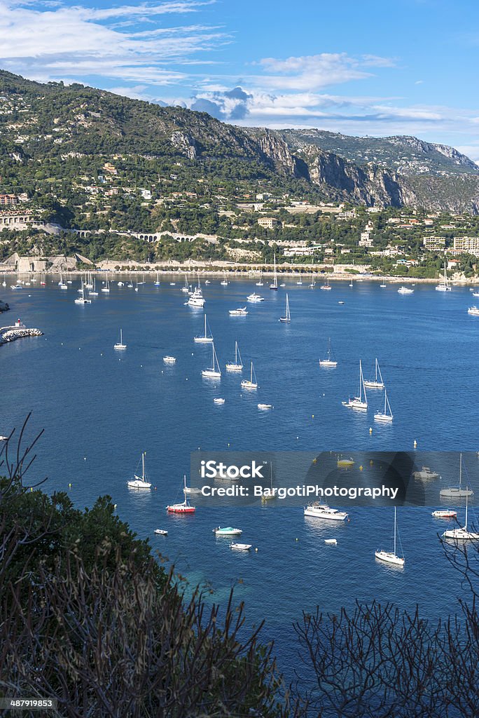 Aerial view of Villefranche-sur-Mer coast with yachts sailing in Villefranche-sur-Mer adjoins the city of Nice to the east along Mont Boron, Mont Alban and Mont Vinaigrier, and 10 km (6.2 mi) south west of Monaco Bay of Water Stock Photo