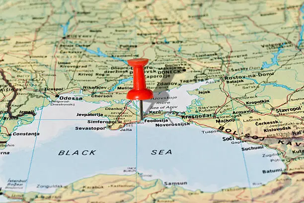 Feodosija in Crimea Ukraine marked with red pushpin on map. Selected focus on Feodosija and pushpin. Pushpin is in an angle and casts shadow to the right.