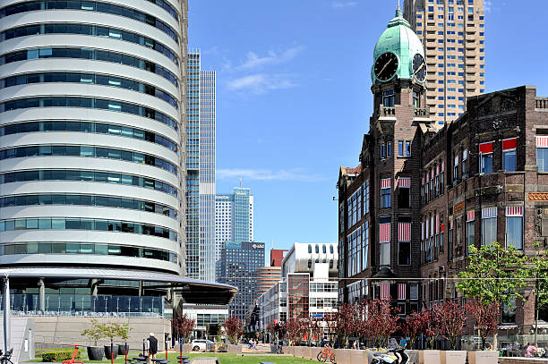 Rotterdam, The Netherlands - May 22, 2014: View at the modern architecture next to the old Hotel New York along the Wilhelminakade in the Kop van Zuid district in Rotterdam. Modern buildings on the left are the World Port Center, De Rotterdam and the Maastoren. On the right: Hotel New York, the former head office of the Holland-Amerika Line, and the new tower New Orleans behind is.