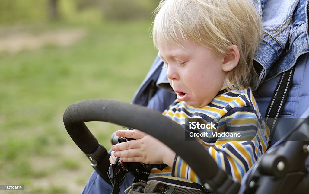 boy crying in baby carriage Baby Carriage Stock Photo