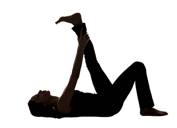 istock Woman doing Reclining Leg Stretching in Yoga, Silhouette View 487922049