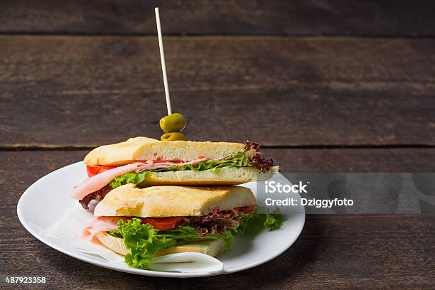 Bocadillo De Jamón En Una Mesa De Madera Foto de stock y más banco de imágenes de 2015 - 2015, Aceituna, Alimento