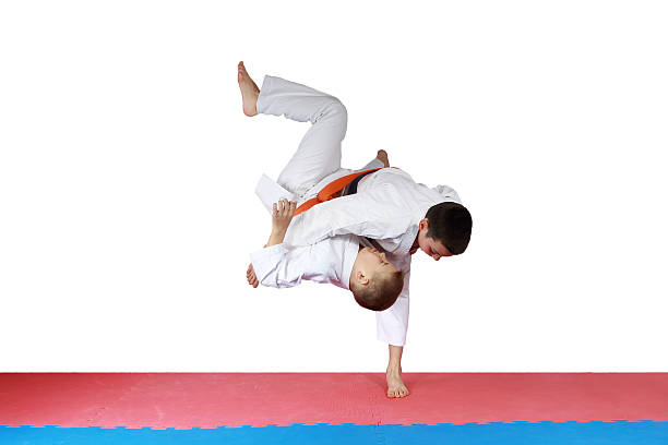 istock Athlete in kimono is throwing athlete with orange belt 487924049