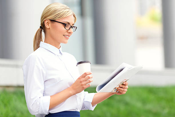 istock Pleasant woman reading newspaper 487924672