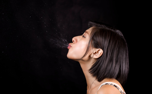 An image of a young Asian girl spitting out water