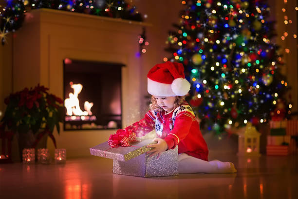 istock Kids opening Christmas presents at fireplace 487925672