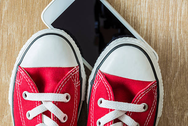 istock Pair of red sneakers and a smartphone 487926020
