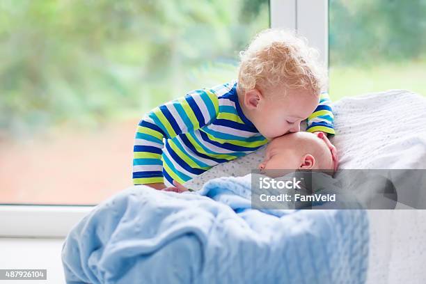 Little Boy Kissing Newborn Baby Brother Stock Photo - Download Image Now - Baby - Human Age, Sibling, Brother