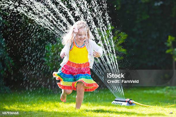 Kids Playing With Garden Sprinkler Stock Photo - Download Image Now - Child, Playful, Playing