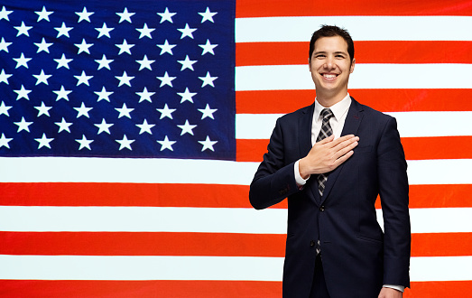 Smiling businessman in front of American flaghttp://www.twodozendesign.info/i/1.png