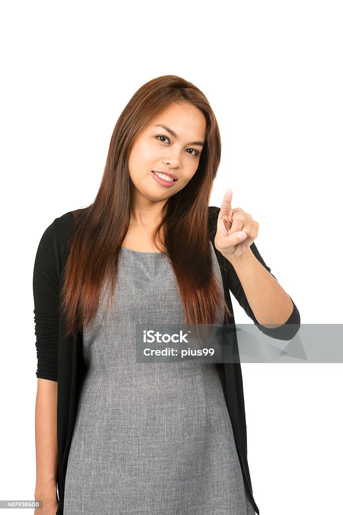 Asian Woman Index Finger Pressing At Camera Lovely Asian woman in black sweater with light brown hair looking at camera with raised index finger pressing, interacting imaginary button or touchscreen interface. Thai national of Chinese origin 20-29 Years Stock Photo