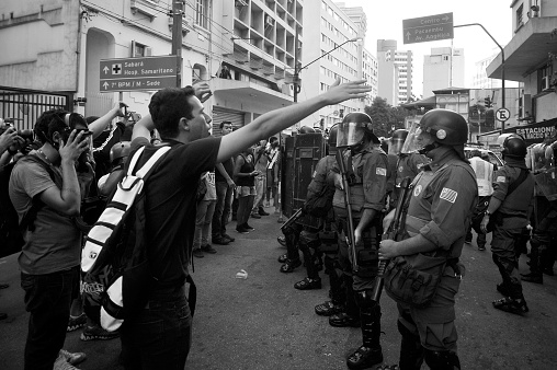 São Paulo, Brazil, January, 09, 2015: Man argues with riot police officers in act for the reduction of transport tariffs in Consolação Avenue