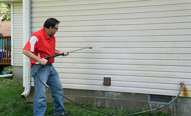 istock Contractor Using A Pressure Washer To Clean Vinyl Siding 487941022