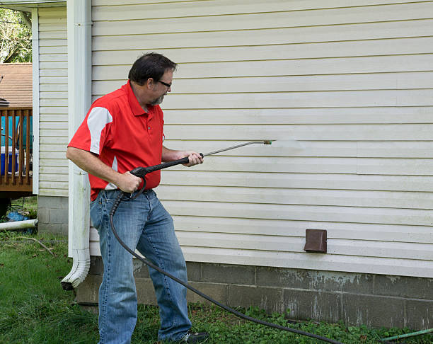 istock Contractor Using A Pressure Washer To Clean Vinyl Siding 487941028