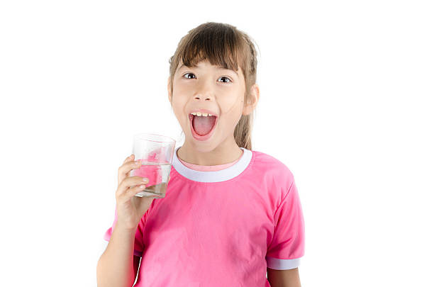 istock Little girl drinking water from glass on white background 487941382