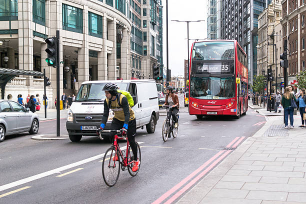 cyclicts i nowoczesne czerwony autobus w londynie, - editorial english culture british culture outdoors zdjęcia i obrazy z banku zdjęć