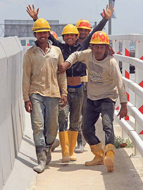 builders are rejoicing to someone on the street in Johor Johor Bahru, Malaysia - April 8, 2015: builders are rejoicing to someone on the street in Johor Bahru johor photos stock pictures, royalty-free photos & images