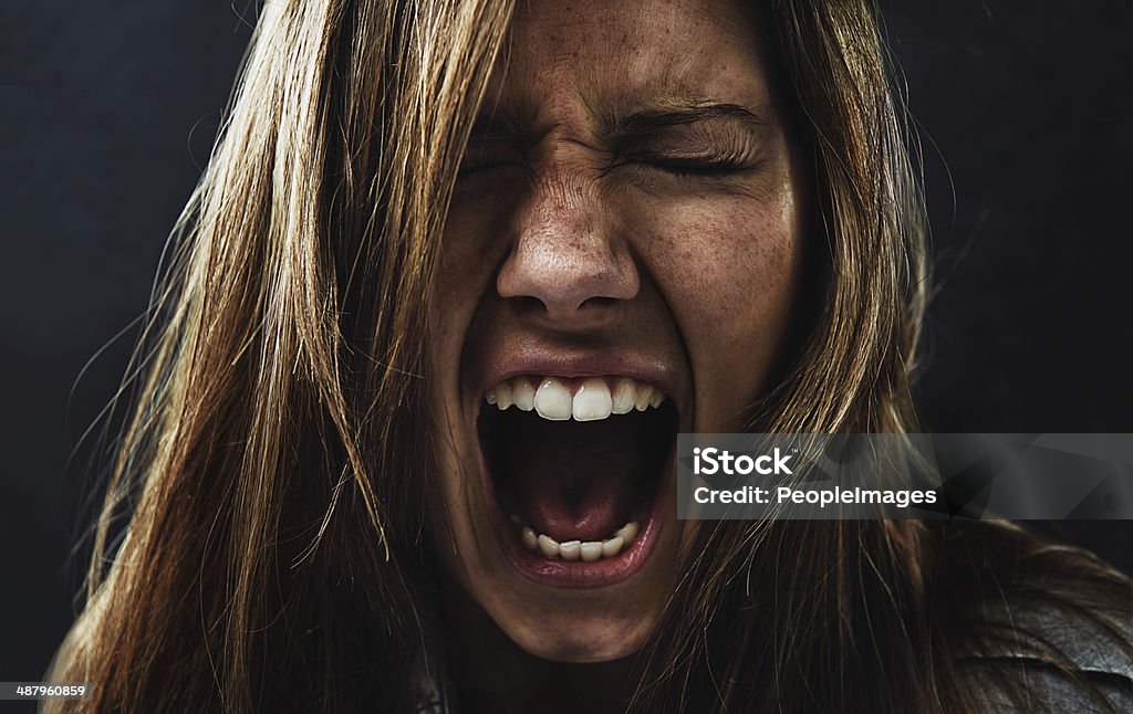She's reached the end of her rope! A young woman screaming uncontrollably while isolated on a black background Shouting Stock Photo