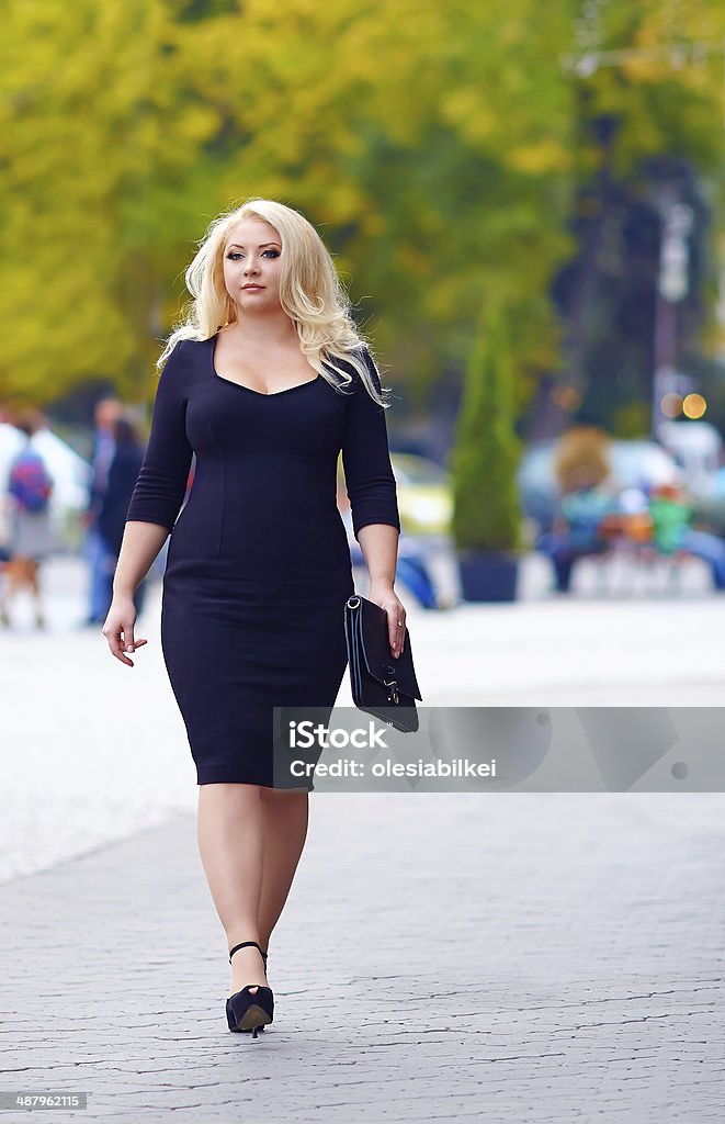 confident overweight woman walking the city street Blond Hair Stock Photo