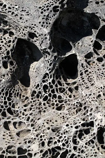 The sea erodes stone in strange patterns.