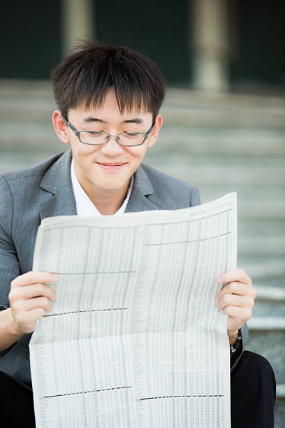 istock Young businessman reading newspaper 487963175