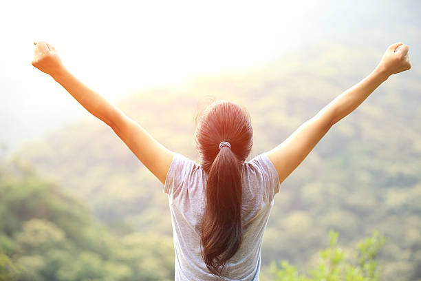 istock cheering  woman open arms at mountain peak 487964515