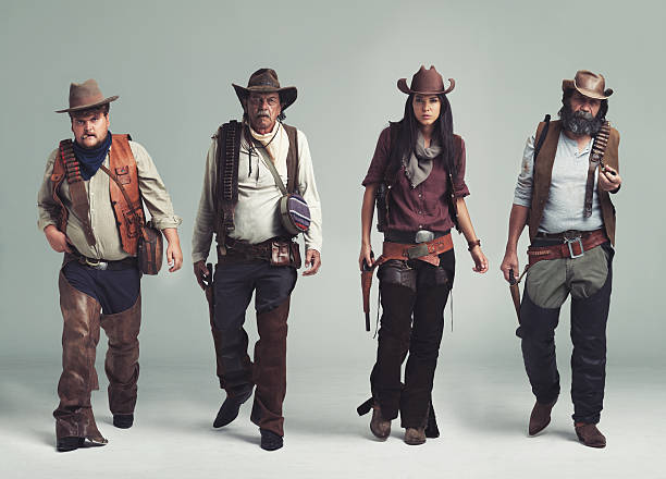 You won't find a more diabolical band of outlaws! A band of outlaws walking while isolated on gray cowboy stock pictures, royalty-free photos & images