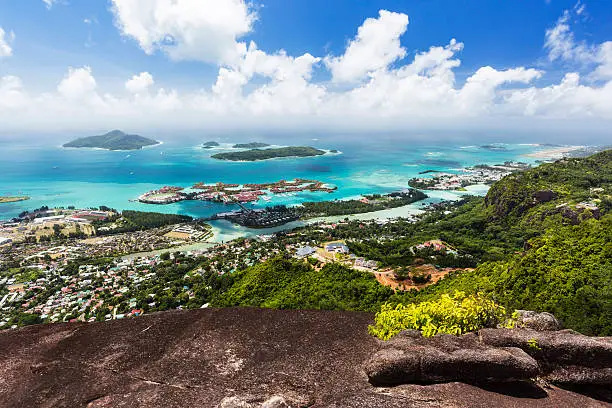 View from Mount Copolia over the east of Mahe, Seychelles with the capital Victoria and Eden Island, granite rock in the foreground.