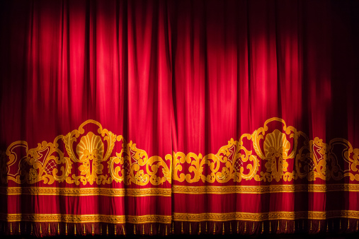 Red stage curtain with arch lights and shadows