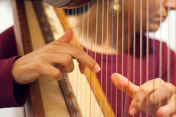 istock Woman playing the harp 487967916