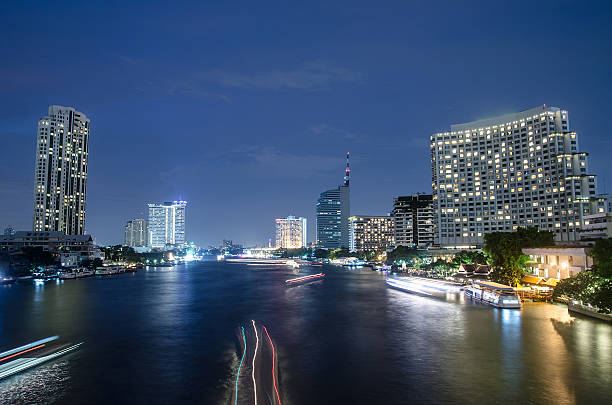 istock Bangkok cityscape with river and boat at night time . 487968898