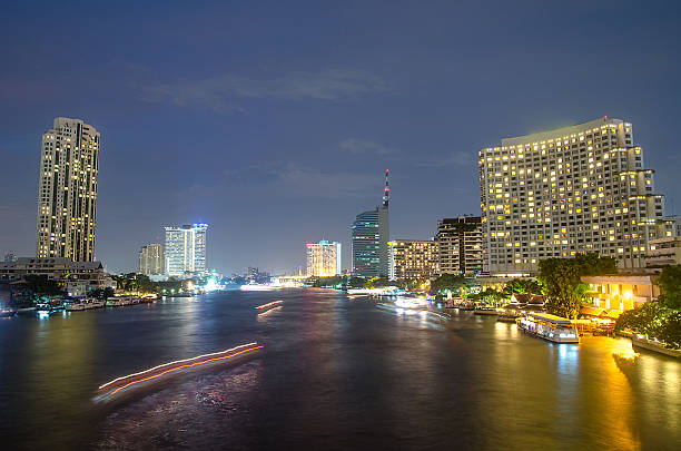 istock Bangkok cityscape with river and boat at night time . 487969396