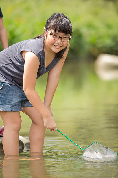 istock Young Asian girl playing by the river 487972370