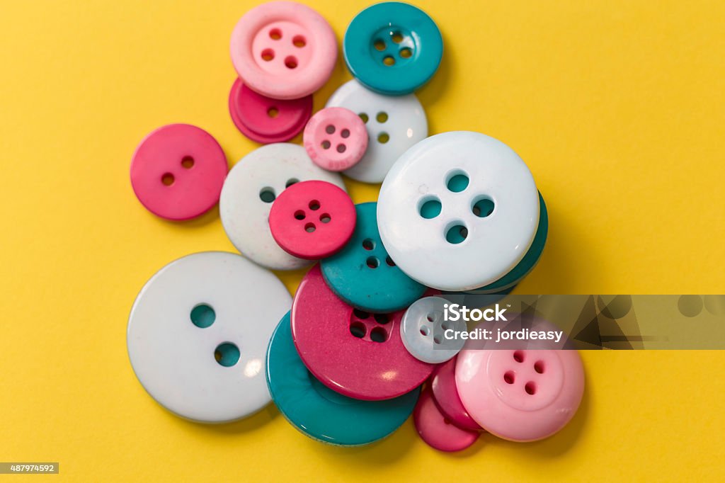 Sew buttons on a yellow background Many different vintage buttons close up isolated on a yellow background 2015 Stock Photo