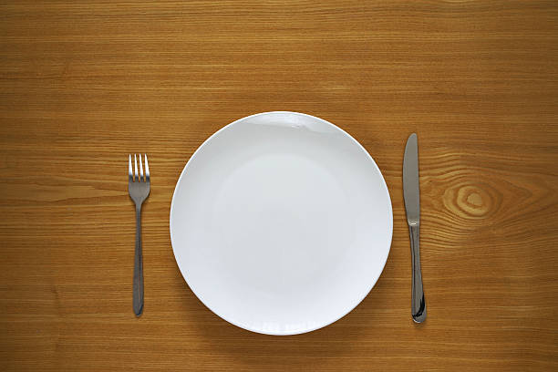 Empty porcelain plate on a wooden table top stock photo