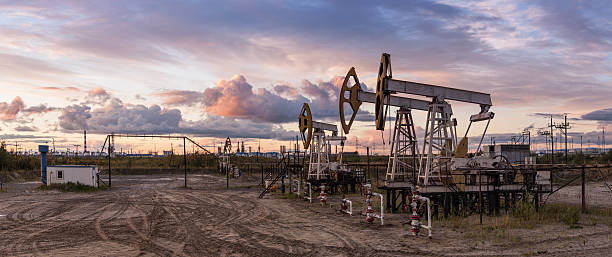 Panoramic oil pumpjack. Oil and gas industry. Panoramic of a pumpjack and oil refinery. oil field stock pictures, royalty-free photos & images