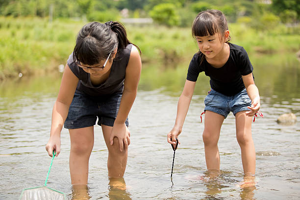 istock Young Asian girls playing in the river 487978560