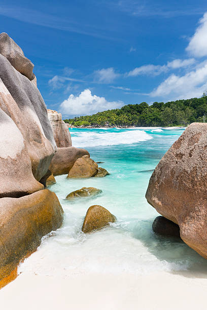 August cloudy day on a warm Seychelles' sandy beach with huge boulders.
