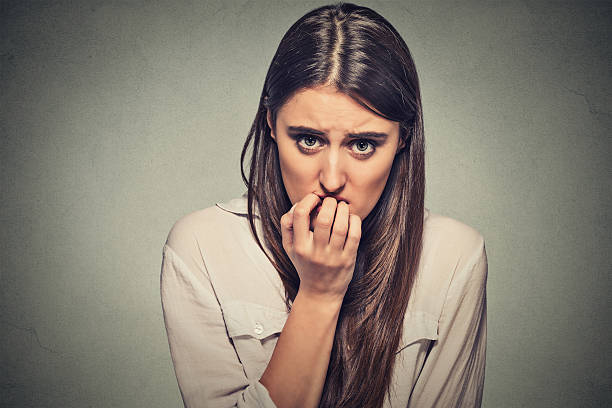 istock anxious unsure hesitant nervous woman biting her fingernails 487979504